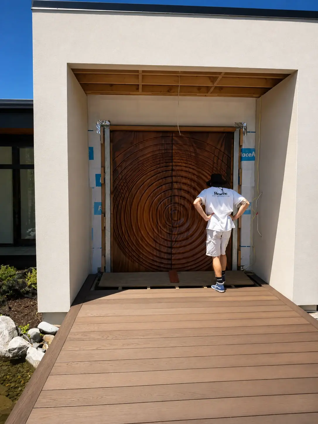 Checking the finish on a pair of tall figured-timber entry doors
